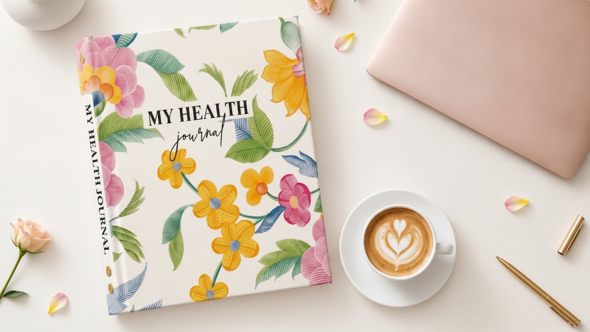 My Health Journal Floral Linen paper health journal displayed on a desk with a notebook, coffee, and pen, designed to help patients and caregivers organize important health information.