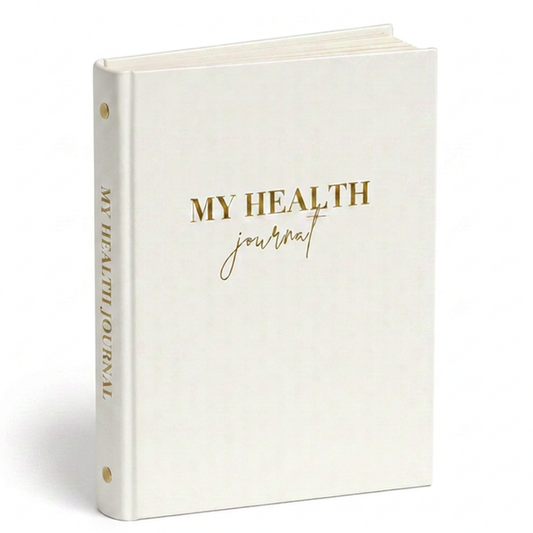 My Health Journal white linen edition with gold lettering, standing upright on a white background